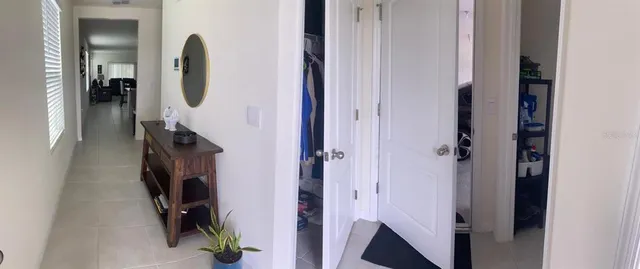 a view of a hallway with closet and mirror