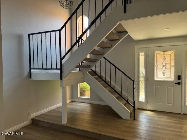 a kitchen with stainless steel appliances white cabinets and a wooden floor
