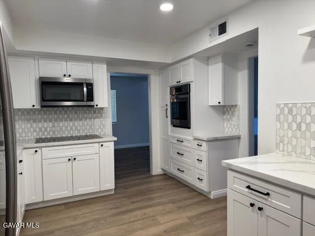a kitchen with a refrigerator sink and cabinets