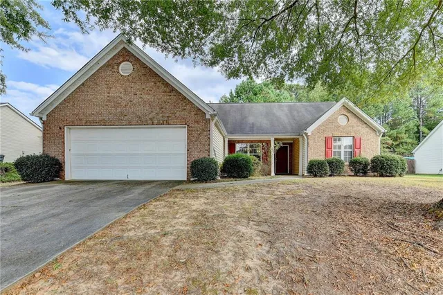 a view of a house with a yard and large tree