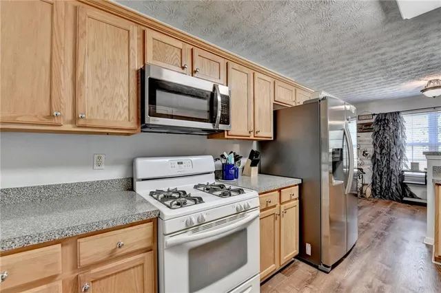 a kitchen with stainless steel appliances granite countertop a refrigerator stove and sink