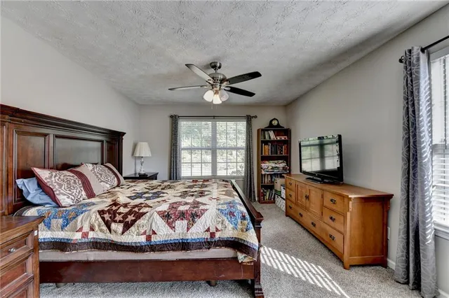 a bedroom with a bed and a flat tv screen on dresser
