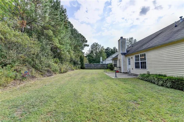a view of a house with backyard and sitting area