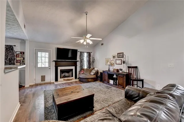 a living room with furniture a fireplace and a flat screen tv