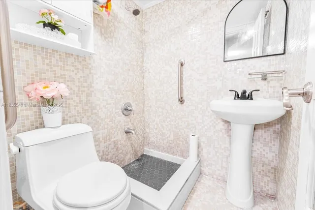a bathroom with a granite countertop toilet sink and mirror