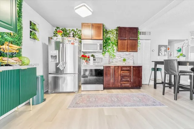 a view of kitchen with furniture and refrigerator