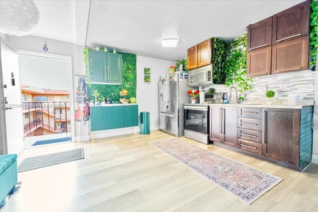 a room with kitchen island a stove a refrigerator and wooden cabinets