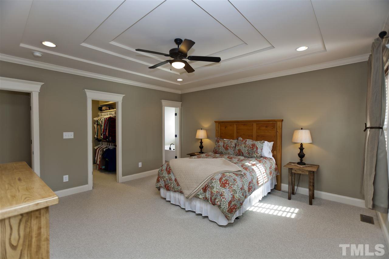101 South Sunset Ridge Drive Willow Spring, NC 27592 - Photo 12 of 25 a spacious bedroom with a bed and a chandelier