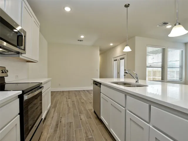 a kitchen with a sink and wooden floor
