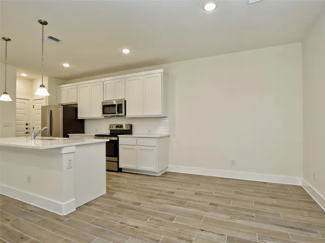 a kitchen with white cabinets and stainless steel appliances