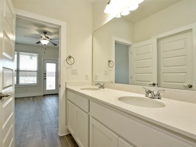 a en suite bathroom with a double vanity sink and a mirror