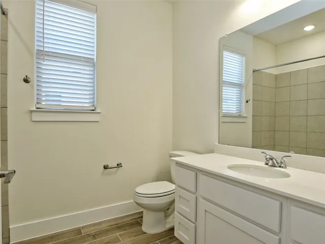 a bathroom with a sink a toilet and a mirror