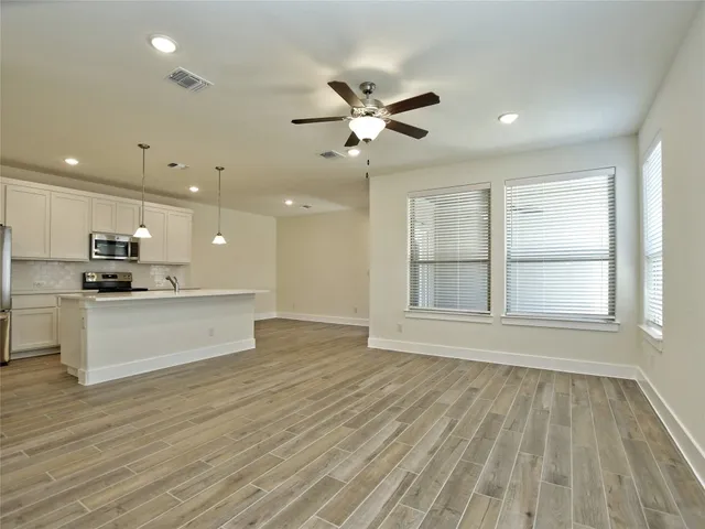 a view of an empty room with kitchen appliances and a window