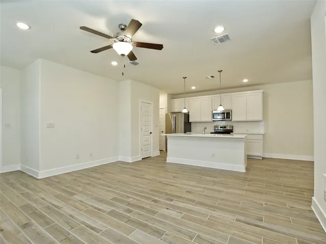 a view of kitchen with refrigerator sink and cabinets