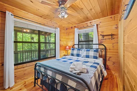 a bedroom with a bed and a large window