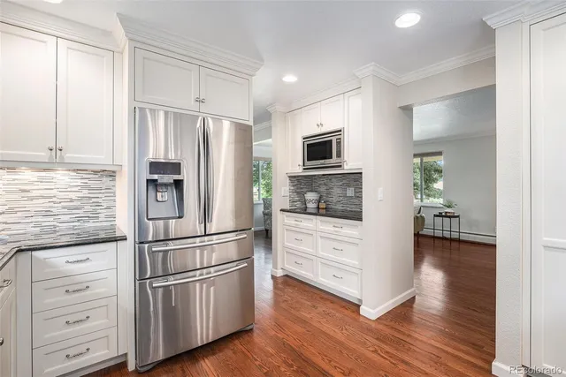 a kitchen with kitchen island wooden floors appliances and cabinets