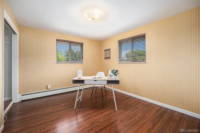 a work room with wooden floor and furniture