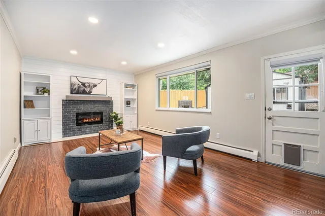 a living room with furniture fireplace and wooden floor