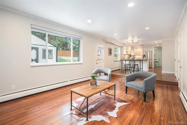 a living room with furniture and a wooden floor