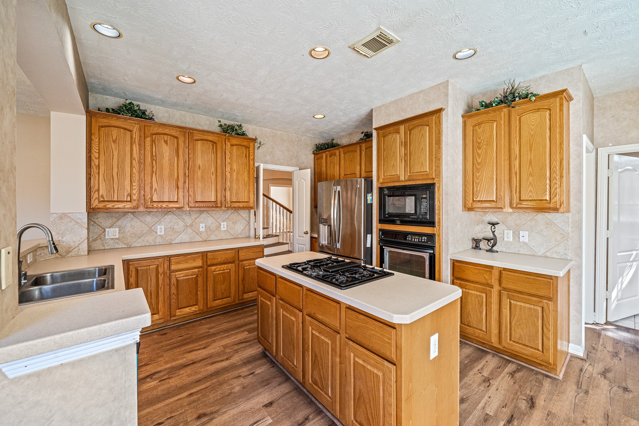 9306 Lochflora Drive Spring, TX 77379 - Photo 14 of 48 a kitchen with stainless steel appliances a stove sink and cabinets