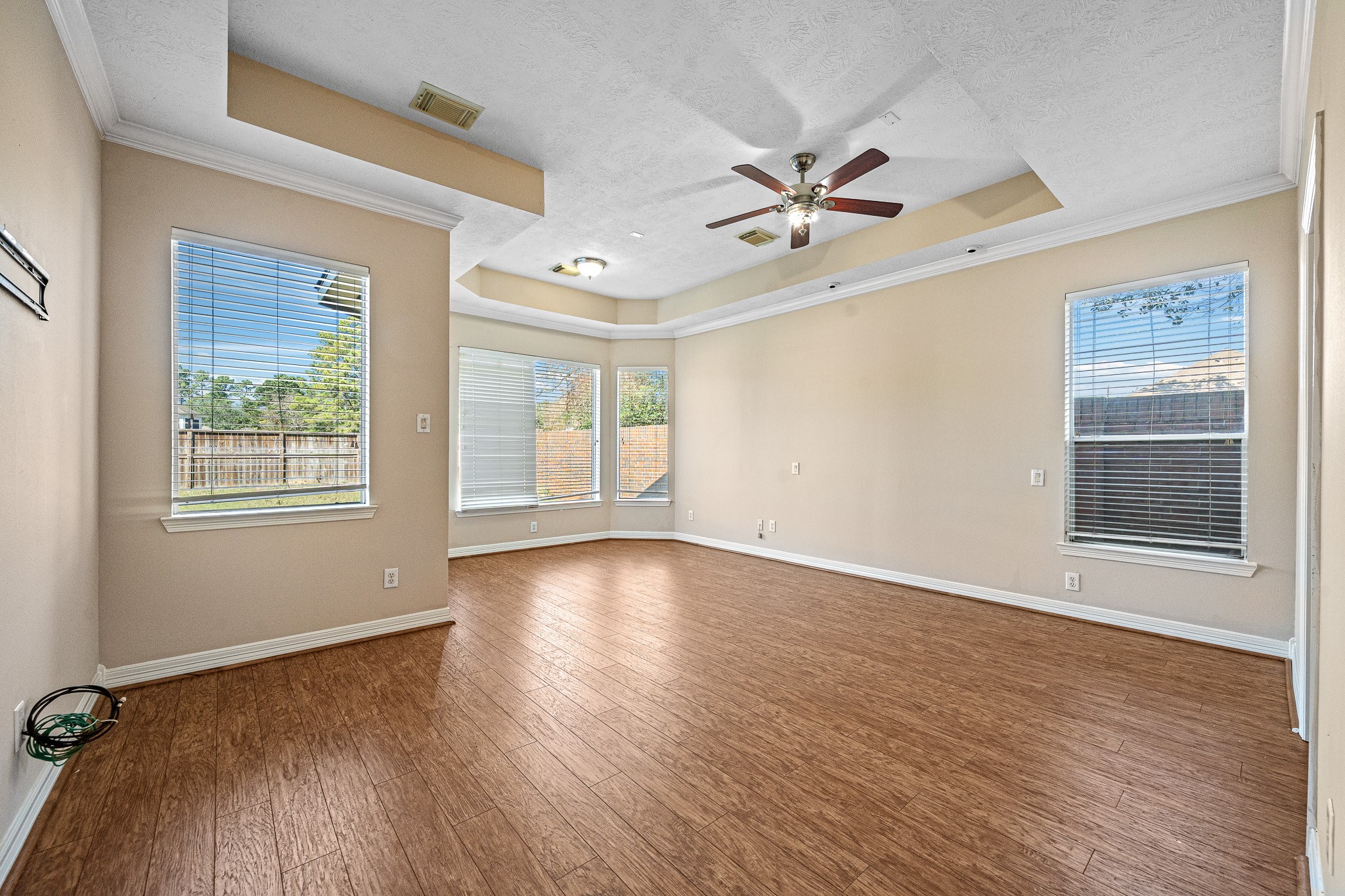 9306 Lochflora Drive Spring, TX 77379 - Photo 18 of 48 an empty room with wooden floor fan and windows