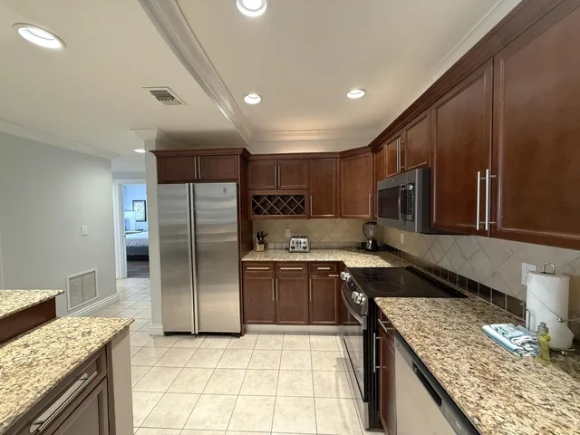 a kitchen with stainless steel appliances granite countertop a sink stove and refrigerator