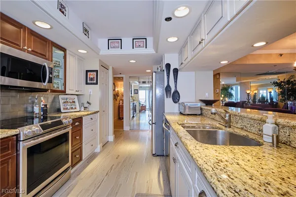 a kitchen with stainless steel appliances granite countertop a sink stove and refrigerator