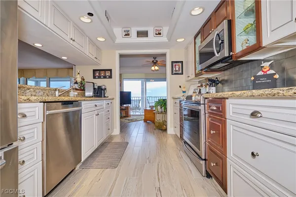 a kitchen with stainless steel appliances granite countertop lots of counter top space and wooden floors