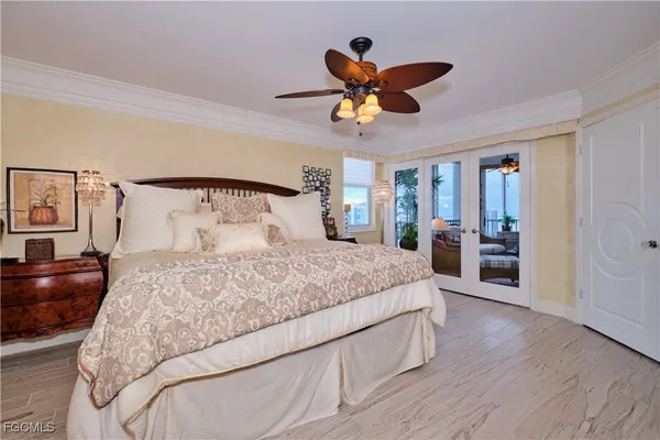 a bedroom with a large bed and a chandelier