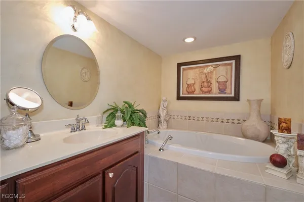 a bathroom with a tub sink and mirror