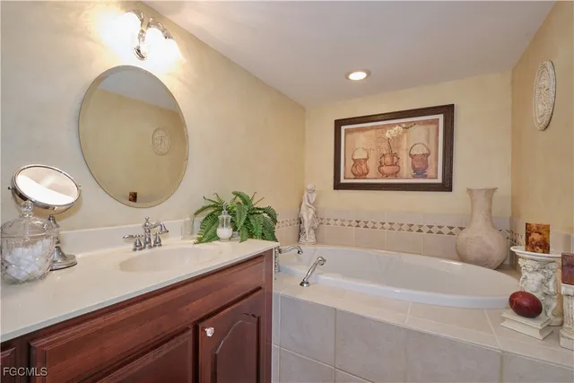 a bathroom with a tub sink and mirror