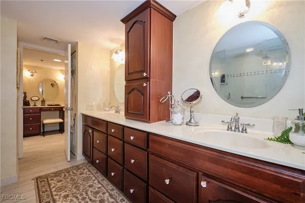 a en suite bathroom with a double vanity sink and a mirror