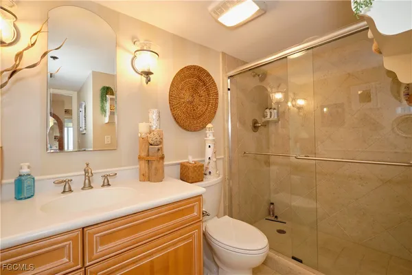 a bathroom with a granite countertop sink mirror vanity and toilet