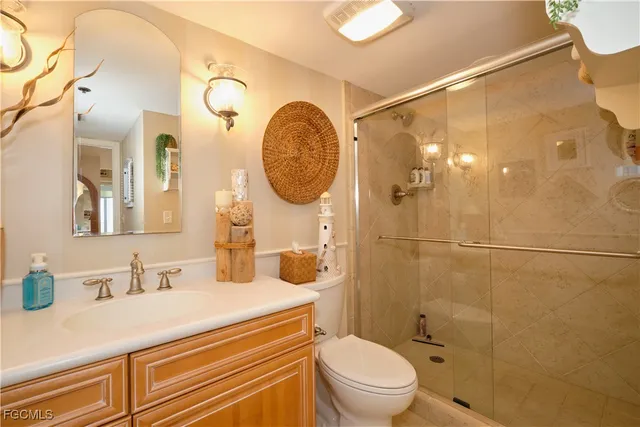 a bathroom with a granite countertop sink mirror vanity and toilet