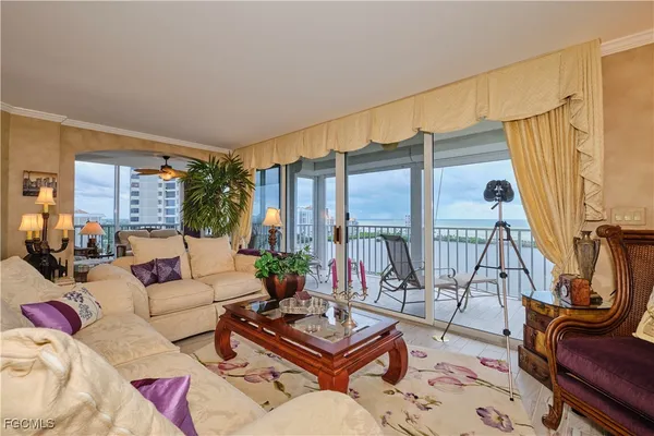 a living room with furniture a rug and a floor to ceiling window