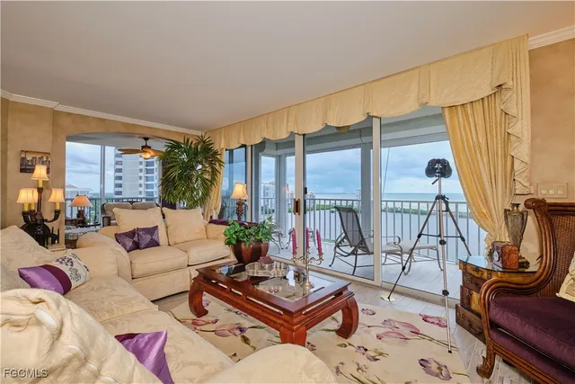 a living room with furniture a rug and a floor to ceiling window