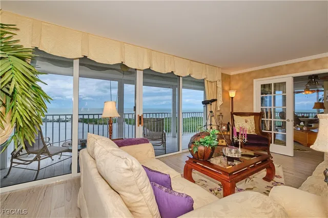 a living room with furniture kitchen view and large windows