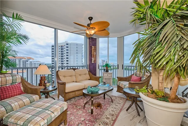 a living room with patio furniture and a potted plant