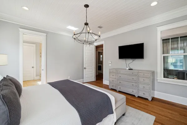 a bedroom with a large bed and a chandelier
