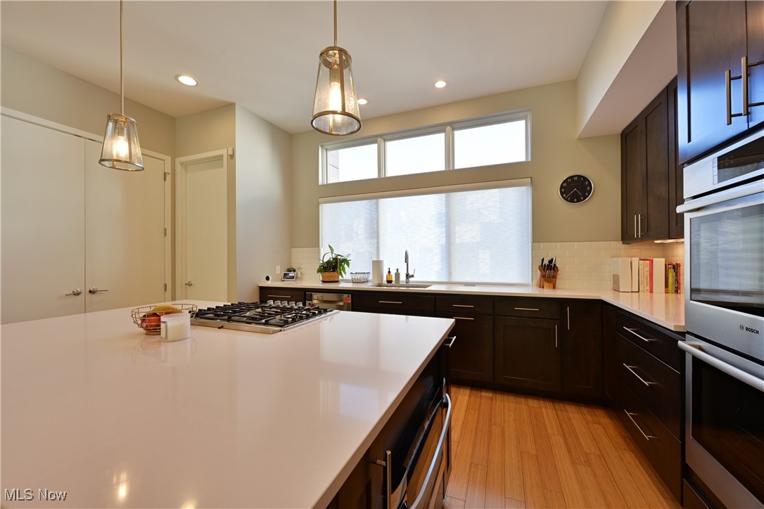 18875 Riversouth Fairview Park, Unit 30 Cleveland, OH 44126 - Photo 10 of 39 Kitchen with appliances with stainless steel finishes, light wood finished floors, hanging light fixtures, recessed lighting, and dark brown cabinets