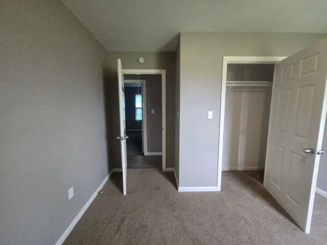 an empty room with closet and a bathroom
