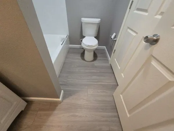 a white toilet sitting in a bathroom next to a sink