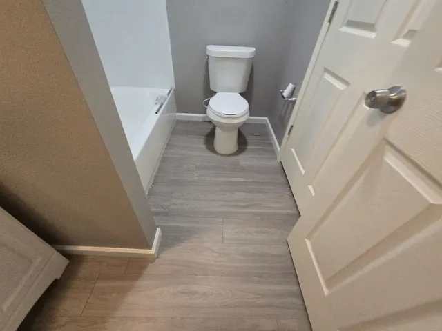 a white toilet sitting in a bathroom next to a sink