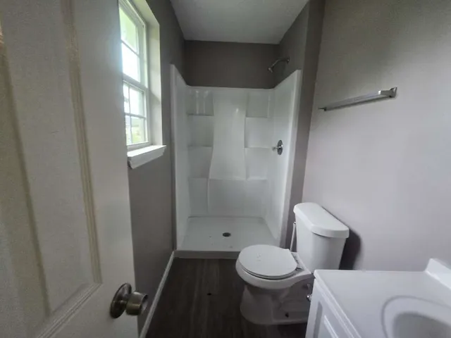 a white toilet sitting next to a bathroom sink and tub