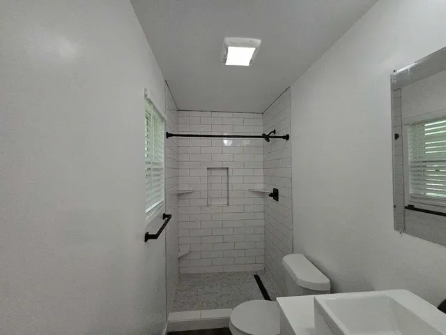 a bathroom with a toilet and a shower