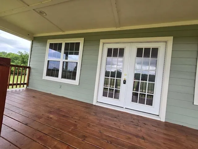 a view of empty room with a large window and wooden floor