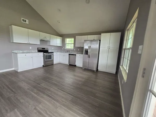 a kitchen with a refrigerator a sink and a stove top oven