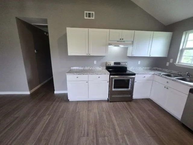 a kitchen with a stove a sink and a refrigerator