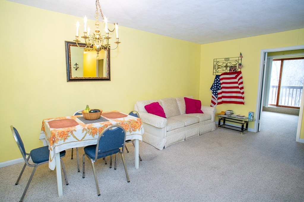 110 Boston Post Road East, Unit 104 Marlborough, MA 01752 - Photo 12 of 28 a living room with furniture and a chandelier