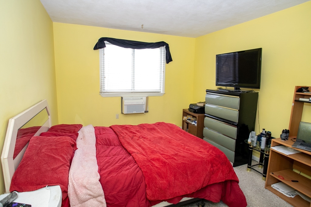 110 Boston Post Road East, Unit 104 Marlborough, MA 01752 - Photo 22 of 28 a bedroom with a bed and a flat screen tv